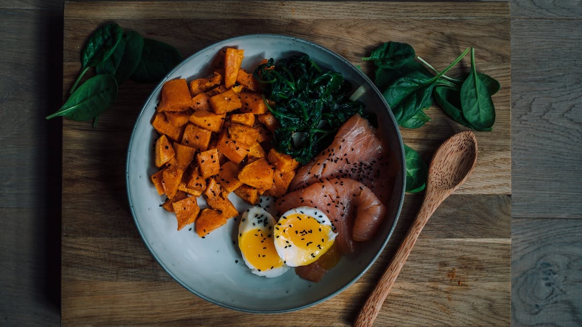 Delicious and nutritious meal featuring salmon, sweet potato, and eggs, perfect for a healthy diet.